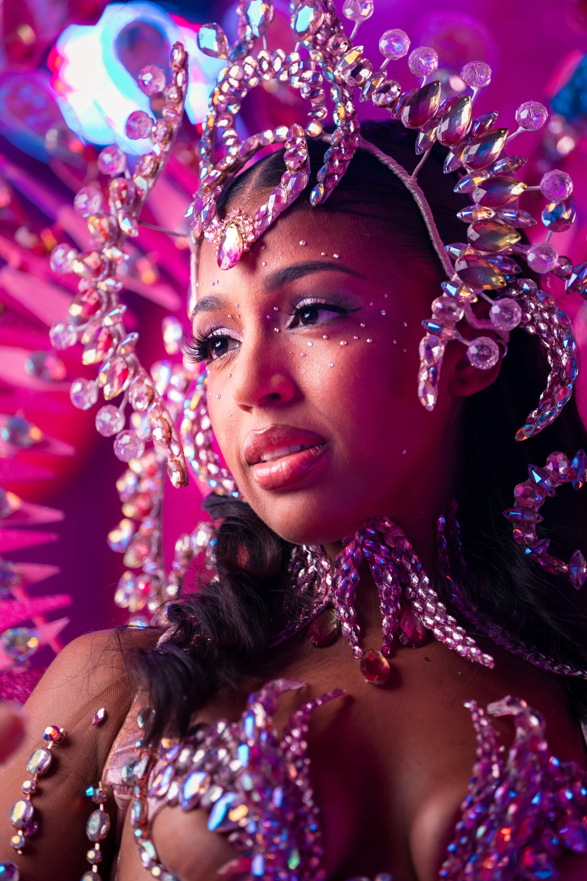 The BLUSH costume shown in full — jewelled bra, belt and leg chains beneath a feathered backpack at full span.