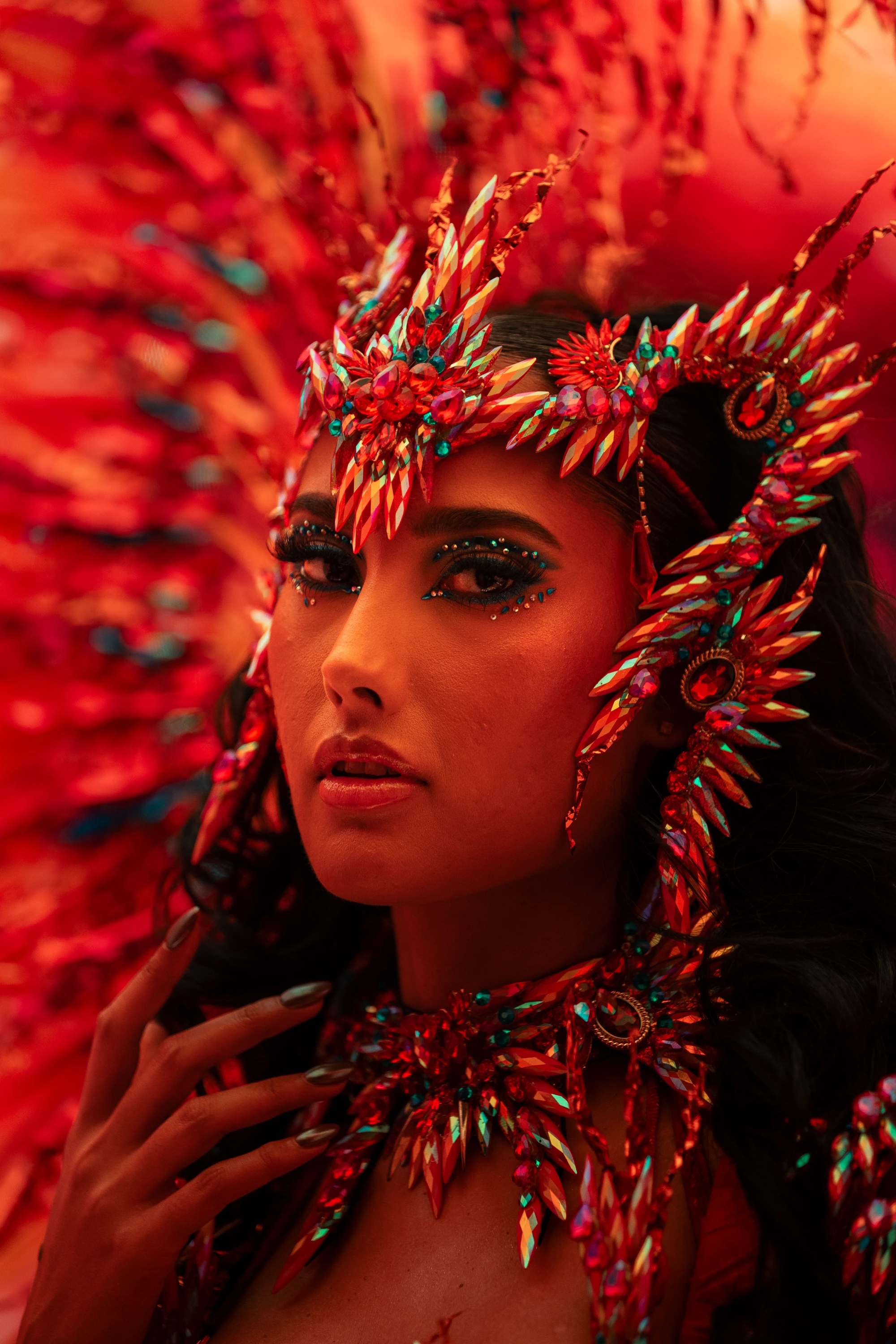 The EMBER costume shown in full — jewelled bra, belt and leg chains beneath a feathered backpack at full span.