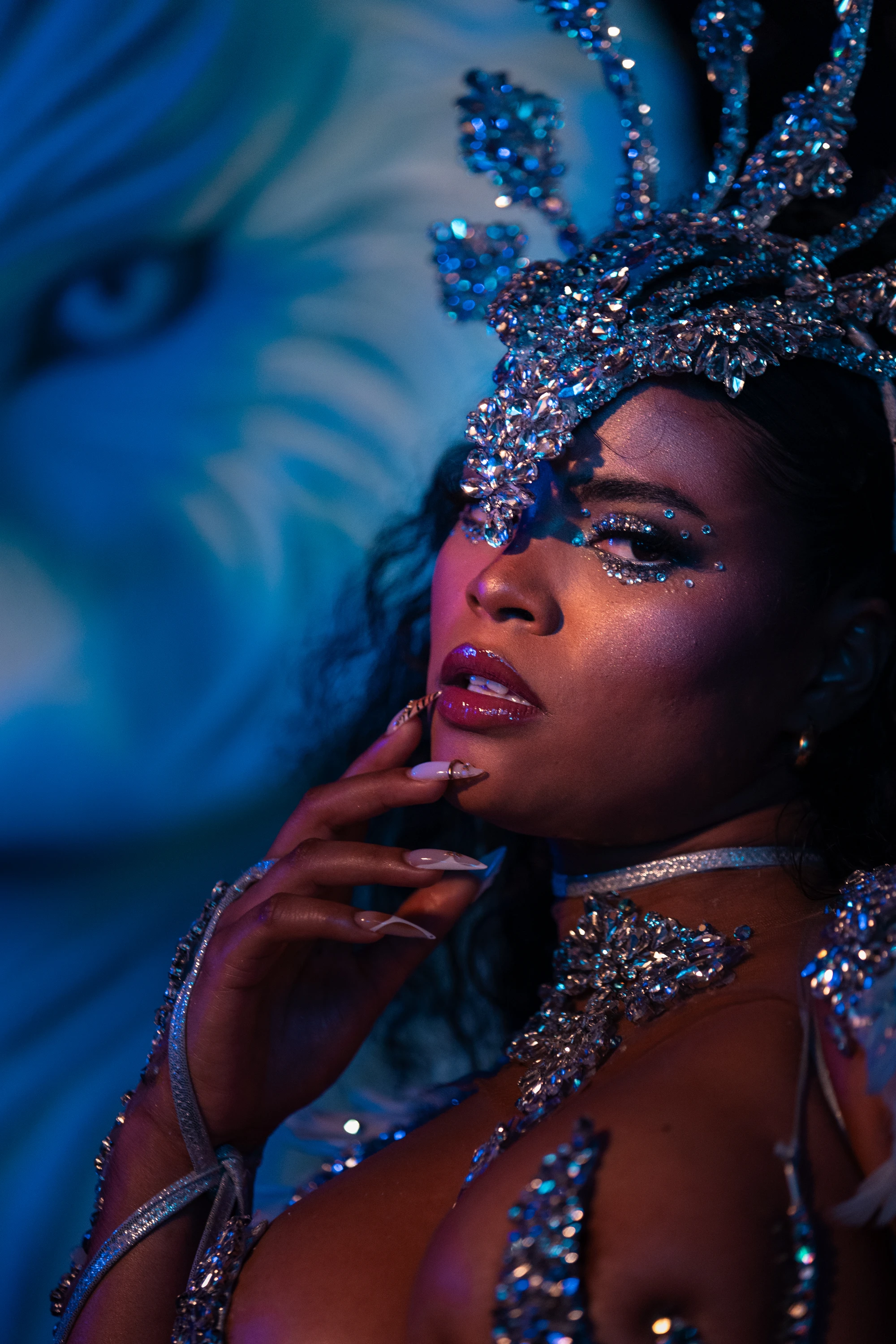 The LUNA costume shown in full — jewelled bra, belt and leg chains beneath a feathered backpack at full span.